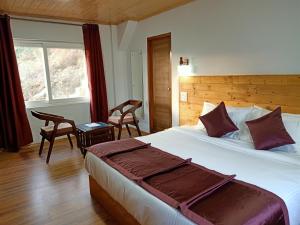 a bedroom with a large bed and a window at Aranyavilas in Shimla
