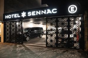 um carro estacionado numa garagem com um sinal de temamine do hotel em Sennac Hotel em Mar del Plata