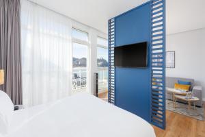 a bedroom with a blue room with a bed and a tv at Hotel San Sebastián Orly, Affiliated by Meliá in Donostia-San Sebastián