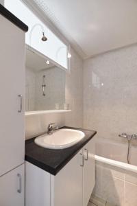 La salle de bains est pourvue d'un lavabo, d'un miroir et d'une baignoire. dans l'établissement Seascape, à Ostende
