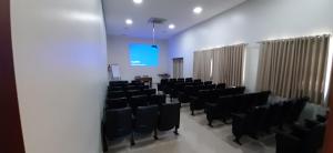 a conference room with black chairs and a blue screen at Guines Palace Hotel in Patrocínio