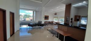 a large room with tables and chairs and a large window at Guines Palace Hotel in Patrocínio