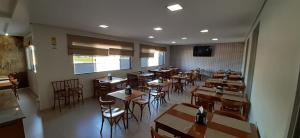 a restaurant with wooden tables and chairs in a room at Guines Palace Hotel in Patrocínio