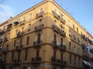 un gran edificio amarillo con ventanas y balcones en Cinquestelle, en Nápoles