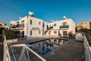 a house with a swimming pool in front of a building at Central Gem - 10 min walk to the sea, harbor and mall in Paphos City