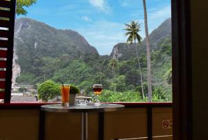 two glasses of wine sitting on a table in front of a window at Chongkhao Resort- SHA Certified in Phi Phi Don