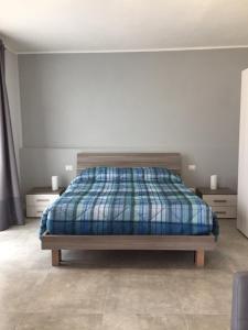 ein Schlafzimmer mit einem Bett mit einer karierten Decke in der Unterkunft Il Caravaggio Guest House in Grassobbio