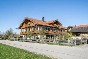 a large wooden house on the side of a road at Ferienwohnungen am Lahnerbach in Lenggries