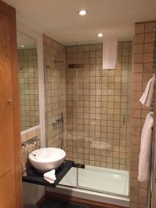 La salle de bains est pourvue d'un lavabo, d'une douche et d'une baignoire. dans l'établissement Rochester Apartment, à Londres
