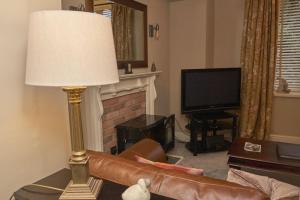 a living room with a couch and a lamp at Old Bakers Cottage ground floor apartment centrally located in Grasmere with patio area in Grasmere