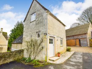 an old brick house with a white door at Bothy in Bibury