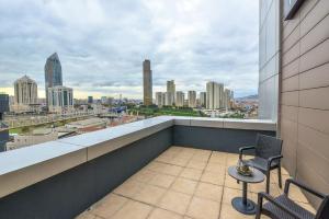 a balcony with two chairs and a view of a city at A11 Hotel Atasehir in Istanbul