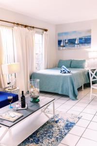 un soggiorno con un letto e un tavolo di Beachside Gardens Apartments By Lowkl a Deerfield Beach Altre 50 foto