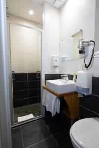 uma casa de banho com um lavatório, um chuveiro e um WC. em Logis Hôtel Restaurant de France em Saint-Geniez-dʼOlt