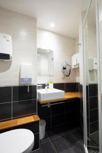 a bathroom with a white toilet and a sink at Logis Hôtel Restaurant de France in Saint-Geniez-dʼOlt