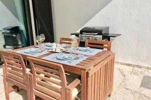 una mesa de madera con sillas y copas de vino en B3 Casares del Mar, en Casares