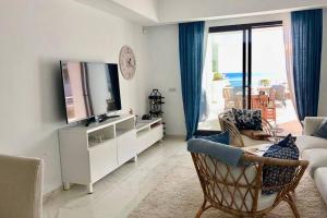 a living room with a television and a couch at B3 Casares del Mar in Casares