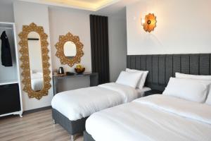 Cette chambre comprend 2 lits et un miroir. dans l'établissement Avcılar Garden Hotel, à Avcılar