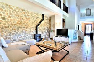 a living room with a couch and a tv at Finca SON RUBI in El Port de la Selva