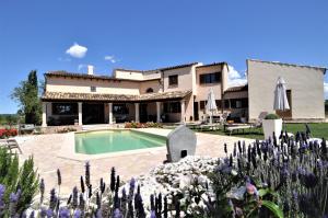 a villa with a swimming pool in front of a house at Finca SON RUBI in El Port de la Selva