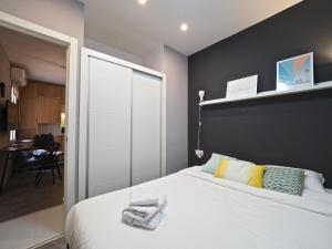 ein Schlafzimmer mit einem weißen Bett und einer schwarzen Wand in der Unterkunft Torrassa Cozy Apartment by Olala Homes in Hospitalet de Llobregat