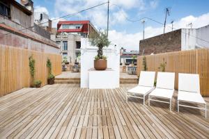 une terrasse avec deux chaises blanches et une plante en pot dans l'établissement Design Apartments by Olala Homes, à L'Hospitalet de Llobregat
