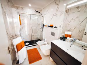 a bathroom with a shower and a toilet and a sink at Apartment Jardins Gold Vista Mar in Portimão