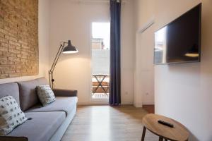 uma sala de estar com um sofá e uma televisão em Design Apartments by Olala Homes em Hospitalet de Llobregat