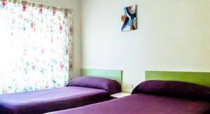 A bed or beds in a room at Hostal Rosa
