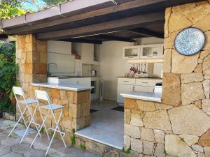 a kitchen with a counter and chairs in a stone wall at Villa Plemmyria in Syracuse +131 photos