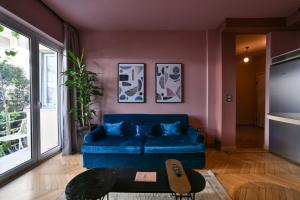 a living room with a blue couch and a table at Kolonaki Boutique Apartments by Olala Homes in Athens