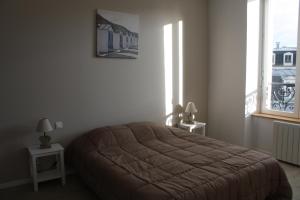 L'ALBATROS في غرانفيل: غرفة نوم بسرير وطاولتين ونوافذ