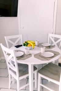 uma mesa branca com uma taça de fruta em Beachside Gardens Apartments By Lowkl em Deerfield Beach