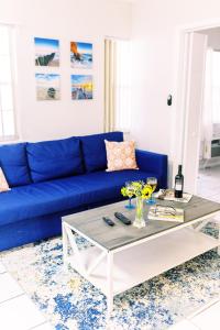 uma sala de estar com um sofá azul e uma mesa de centro em Beachside Gardens Apartments By Lowkl em Deerfield Beach