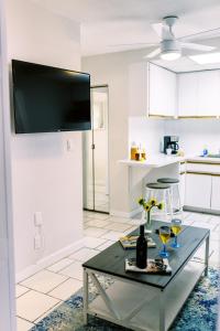 un soggiorno con tavolo e 2 bicchieri di vino di Beachside Gardens Apartments By Lowkl a Deerfield Beach