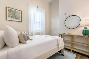 - une chambre blanche avec un miroir et un lit dans l'établissement Urban Retreat Near French Quarter, à La Nouvelle-Orléans