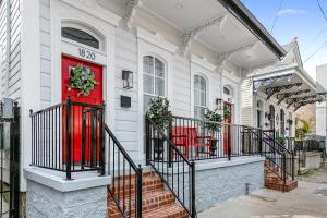 - une porte rouge sur une maison blanche avec des escaliers dans l'établissement Urban Retreat Near French Quarter, à La Nouvelle-Orléans