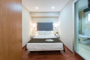 a bedroom with a bed and a bathroom with a sink at Senator Barcelona Apartments in Barcelona