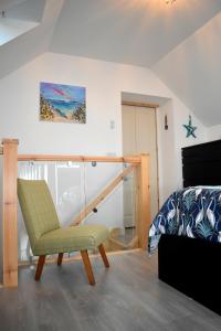 a bedroom with a bed and a chair in a room at Lycia Rooms + in Inverness