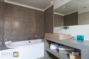 a bathroom with a tub and a sink at Hôtel 96 in Marseille