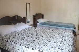 une chambre avec deux lits et un miroir dans l'établissement 3 dormitórios no Guarujá, próximo ao Aquário! Sinta-se em casa!, à Guarujá 23 autres photos