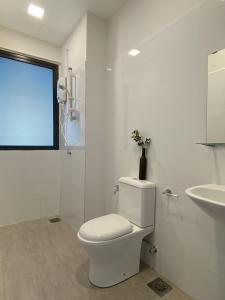 ein weißes Bad mit einem WC und einem Waschbecken in der Unterkunft The Miere Suites @ KLIA Sepang in Sepang