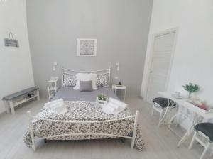 1 dormitorio con 1 cama, mesa y sillas en Dove nasce il Sole B&B en Nicolosi