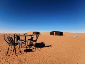 una mesa y sillas en medio del desierto en Bivouac L'Erg, en Mhamid