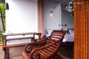 a wooden rocking chair in a room with a bed at OwinHill Cottage in Ella