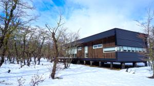 a wooden house in the woods in the snow at Endemiko in Malalcahuello