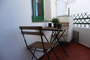 a small table and chair in a room with a window at Apartamento El Ancla - cerca la playa in El Puerto de Santa María