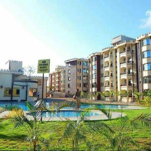 a man is standing in front of some buildings at BLUE NILE 9 - SUNSET HOLIDAY APARTMENTS, SHANZU - Mombasa in Mombasa