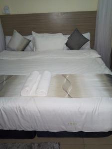 a large white bed with two folded towels on it at BLUE NILE 9 - SUNSET HOLIDAY APARTMENTS, SHANZU - Mombasa in Mombasa