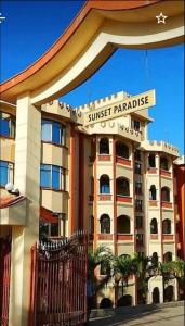 a building with a sunset paradise sign in front of it at BLUE NILE 9 - SUNSET HOLIDAY APARTMENTS, SHANZU - Mombasa in Mombasa